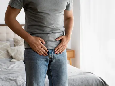 Hombre con molestias en la parte baja del abdomen como representación de problemas de vejiga y vías urinarias.